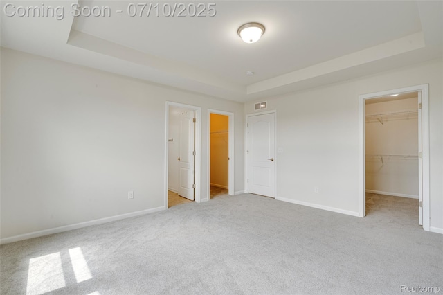 43433 Chancellor Ln, Novi, MI 48375 - unfurnished bedroom with a walk in closet, carpet floors, and a tray ceiling