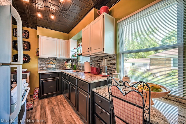 2233 Kohler St, Waterford, MI 48329 - kitchen with white cabinetry, an ornate ceiling, decorative backsplash, light wood-style floors, and light stone countertops