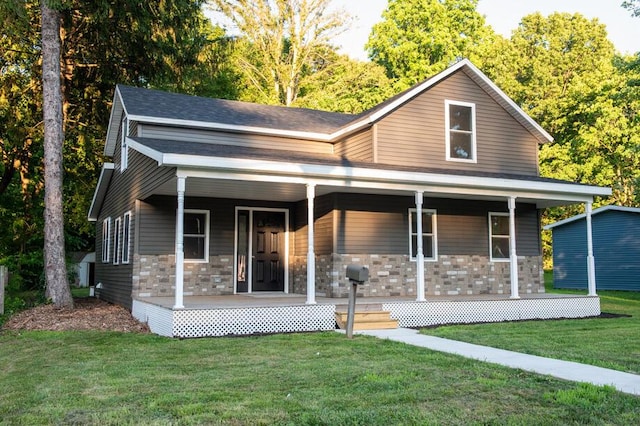 1120 8th St, Three Rivers, MI 49093 - view of front of house with a porch, stone siding, and a front lawn