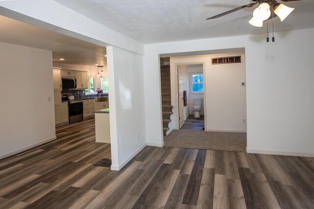 1120 8th St, Three Rivers, MI 49093 - empty room with ceiling fan, dark wood finished floors, and stairway