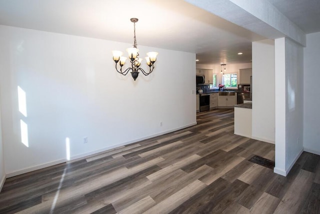 1120 8th St, Three Rivers, MI 49093 - unfurnished living room with a chandelier, dark wood-style flooring, and recessed lighting