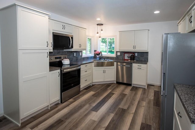 1120 8th St, Three Rivers, MI 49093 - kitchen featuring appliances with stainless steel finishes, tasteful backsplash, dark wood finished floors, white cabinets, and recessed lighting