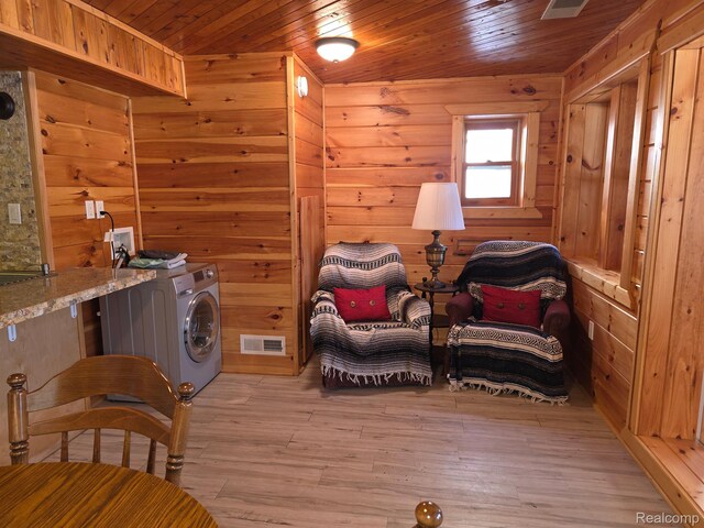 221 Bluegill Lake Dr, Frost, MI 48625 - living area featuring wood walls, light wood-style floors, washer / dryer, and wood ceiling
