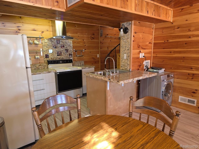 221 Bluegill Lake Dr, Frost, MI 48625 - kitchen featuring white appliances, island range hood, wooden walls, white cabinetry, and light stone countertops