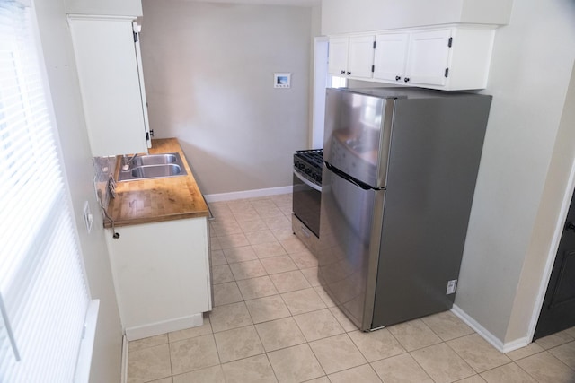 3061 Homewood St SW, Grandville, MI 49418 - kitchen featuring stainless steel appliances, light tile patterned flooring, healthy amount of natural light, and white cabinetry
