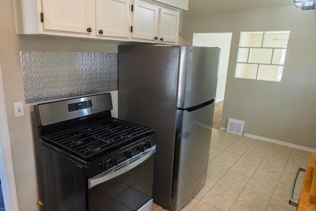 3061 Homewood St SW, Grandville, MI 49418 - kitchen with appliances with stainless steel finishes, white cabinetry, and light tile patterned flooring