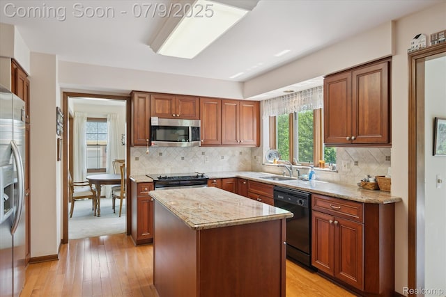 48721 W Normandy Ct, Plymouth, MI 48170 - kitchen with stainless steel appliances, light stone counters, light wood-style flooring, and a center island