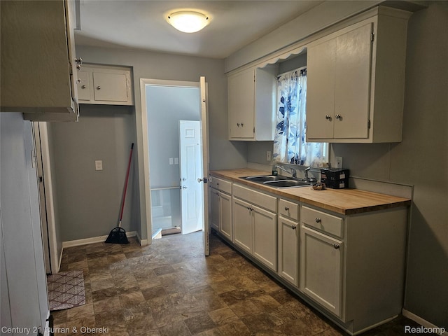 19370 Dequindre St, Detroit, MI 48234 - kitchen featuring white cabinets, butcher block countertops, and stone finish flooring
