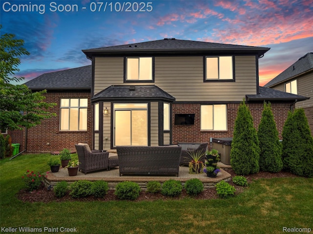 62777 Franklin Park Dr, Washington, MI 48094 - back of house at dusk with a yard, a patio, a hot tub, brick siding, and an outdoor living space