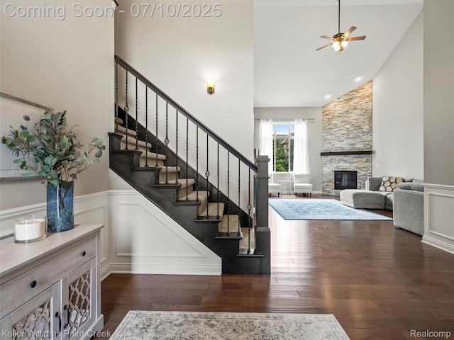62777 Franklin Park Dr, Washington, MI 48094 - stairway with high vaulted ceiling, a wainscoted wall, a ceiling fan, hardwood / wood-style flooring, and a stone fireplace