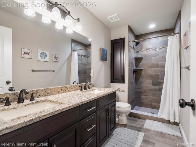 62777 Franklin Park Dr, Washington, MI 48094 - bathroom with a tile shower, double vanity, and wood finished floors