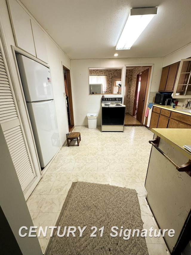 2410 Jossman Rd, Holly, MI 48442 - kitchen with range with electric cooktop, freestanding refrigerator, and light countertops