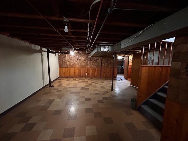 26219 Clarita St, Redford, MI 48240 - unfinished below grade area with wood walls, tile patterned floors, and stairway