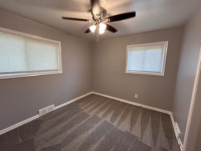 26219 Clarita St, Redford, MI 48240 - spare room featuring dark colored carpet, a ceiling fan, and plenty of natural light