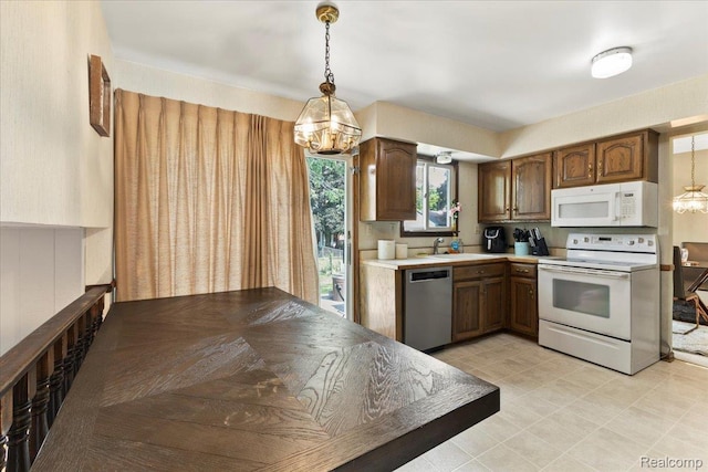 42109 Hartford Dr, Canton, MI 48187 - kitchen featuring white appliances, decorative light fixtures, light countertops, and a chandelier