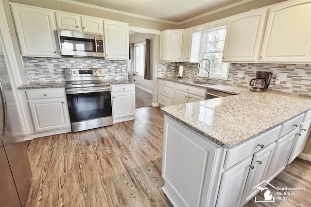 3380 Stewart Rd, Monroe, MI 48162 - kitchen with stainless steel appliances, light stone counters, light wood-type flooring, backsplash, and crown molding