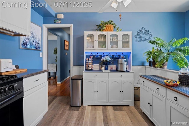 1946 Carlysle St, Dearborn, MI 48124 - kitchen featuring black range with gas stovetop, light wood finished floors, white cabinets, and dark countertops
