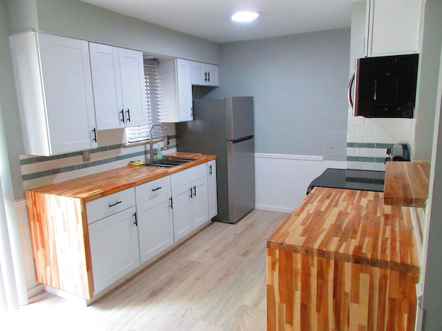 3736 Maryland Ave, Flint, MI 48506 - kitchen with wooden counters, freestanding refrigerator, decorative backsplash, light wood-style floors, and white cabinets