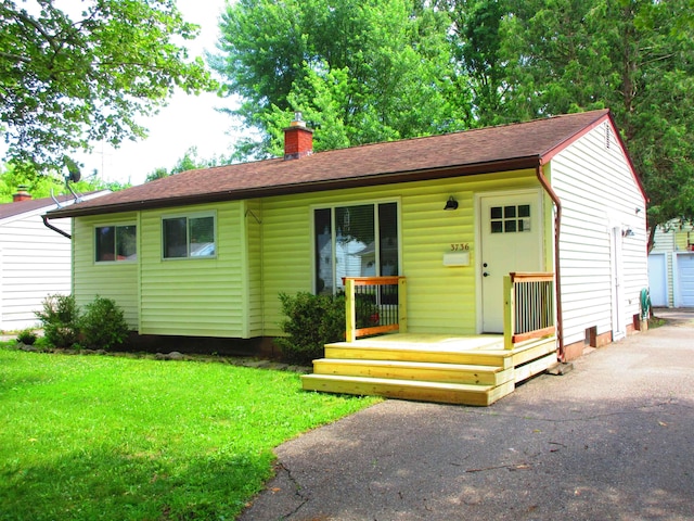 3736 Maryland Ave, Flint, MI 48506 - single story home with a chimney, an outdoor structure, a front lawn, and roof with shingles
