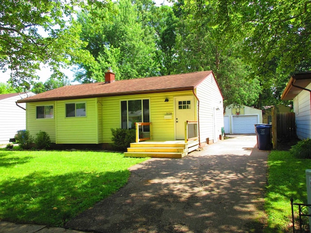 3736 Maryland Ave, Flint, MI 48506 - view of front of property with an outbuilding, a chimney, a front yard, a detached garage, and a shingled roof