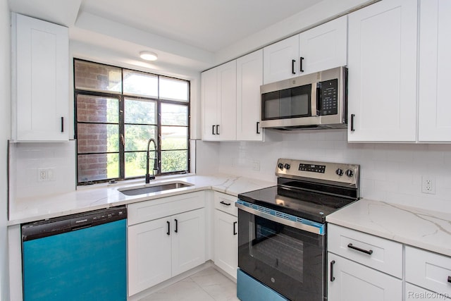 23461 Avon Rd, Oak Park, MI 48237 - kitchen with appliances with stainless steel finishes, white cabinets, light stone countertops, and decorative backsplash