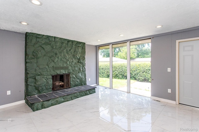 23461 Avon Rd, Oak Park, MI 48237 - unfurnished living room with marble tiled floors, recessed lighting, a stone fireplace, expansive windows, and a textured ceiling