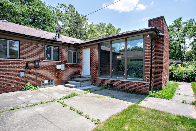 23461 Avon Rd, Oak Park, MI 48237 - view of front of house with a chimney, brick siding, and a patio area