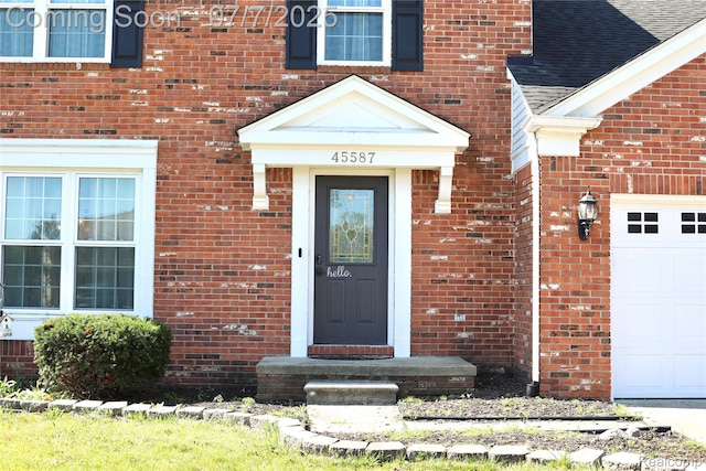 45587 Hanford Rd, Canton, MI 48187 - view of exterior entry with brick siding, roof with shingles, and an attached garage