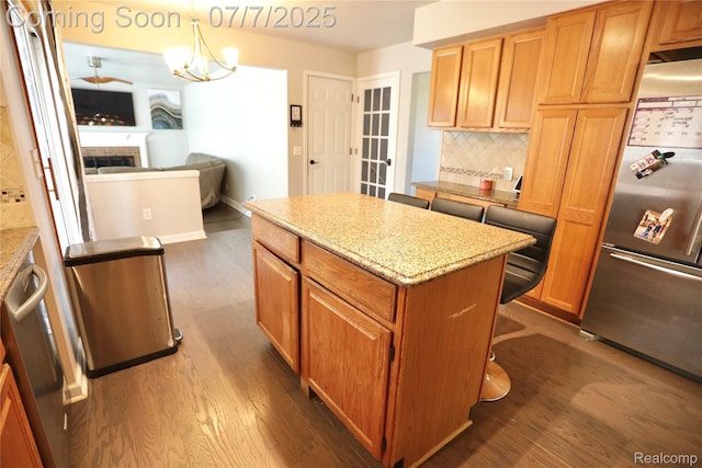 45587 Hanford Rd, Canton, MI 48187 - kitchen with stainless steel fridge, dark wood-type flooring, backsplash, a kitchen island, and light stone counters