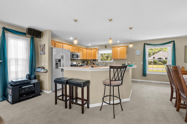 8181 Fawn Meadow Trl, Galesburg, MI 49053 - kitchen with appliances with stainless steel finishes, light carpet, a kitchen bar, decorative light fixtures, and light brown cabinets