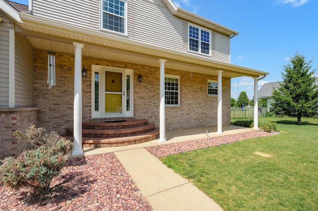 8181 Fawn Meadow Trl, Galesburg, MI 49053 - doorway to property with a yard, brick siding, and a porch