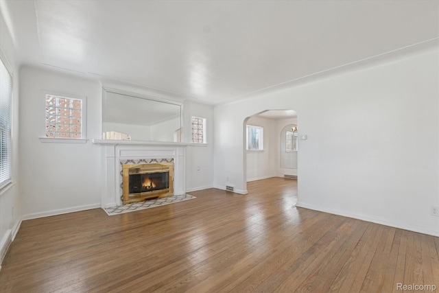 19340 Appoline St, Detroit, MI 48235 - unfurnished living room with arched walkways, hardwood / wood-style floors, and a fireplace