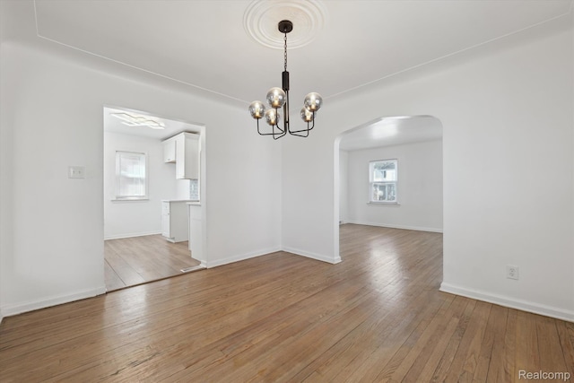 19340 Appoline St, Detroit, MI 48235 - unfurnished room featuring arched walkways, a chandelier, and light wood-type flooring