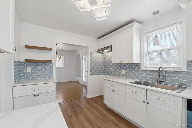 19340 Appoline St, Detroit, MI 48235 - kitchen with light countertops, white cabinets, wood finished floors, arched walkways, and pendant lighting