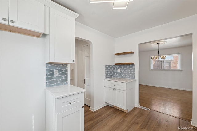 19340 Appoline St, Detroit, MI 48235 - kitchen featuring decorative backsplash, light wood-style floors, white cabinetry, open shelves, and arched walkways