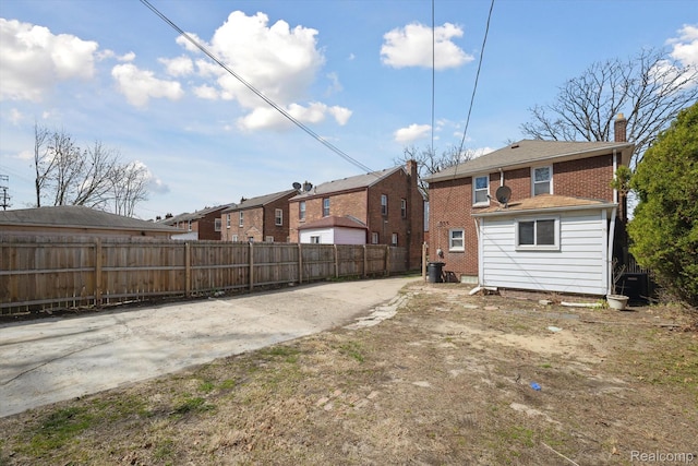 19340 Appoline St, Detroit, MI 48235 - rear view of property featuring brick siding, a residential view, concrete driveway, and a chimney