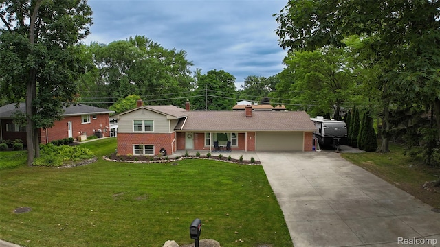 21102 Knudsen Dr, Grosse Ile, MI 48138 - tri-level home with brick siding, concrete driveway, a garage, a front lawn, and a chimney