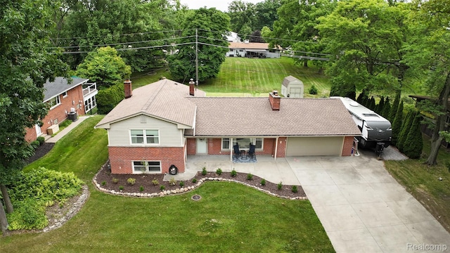 21102 Knudsen Dr, Grosse Ile, MI 48138 - view of front of house featuring brick siding, a garage, concrete driveway, and a storage unit