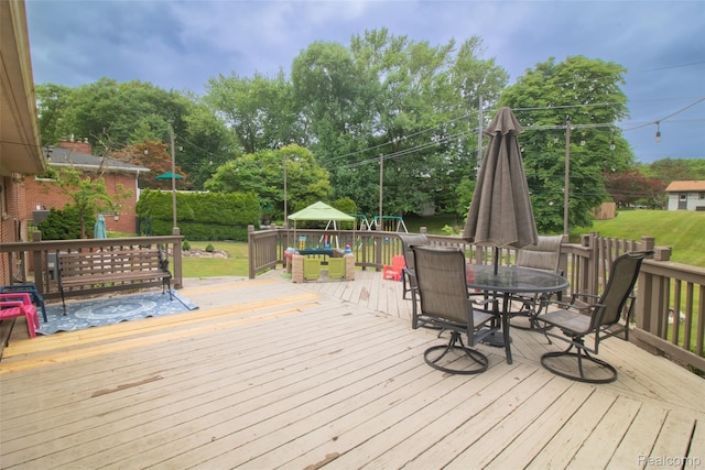 21102 Knudsen Dr, Grosse Ile, MI 48138 - wooden deck with outdoor dining space and view of wooded area
