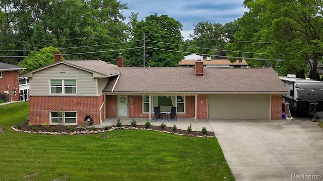 21102 Knudsen Dr, Grosse Ile, MI 48138 - split level home featuring brick siding, a garage, driveway, a chimney, and a front lawn