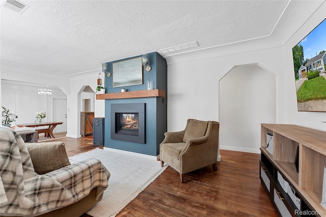 6917 Belton St, Garden City, MI 48135 - living room featuring a fireplace, arched walkways, wood finished floors, and a textured ceiling