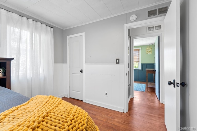 6917 Belton St, Garden City, MI 48135 - bedroom featuring wood finished floors, ornamental molding, and wainscoting