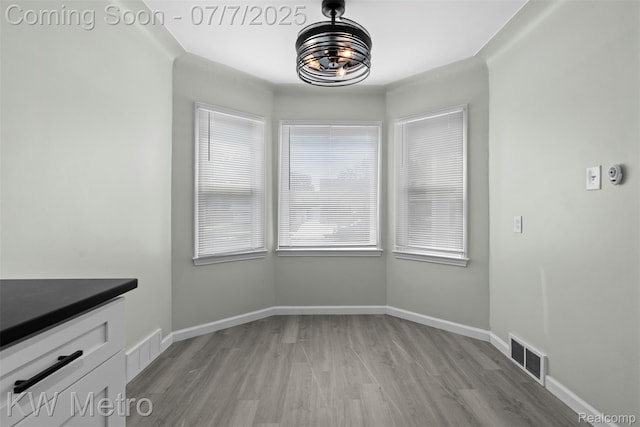 18258 Manor St, Detroit, MI 48221 - unfurnished dining area with light wood-type flooring and a chandelier