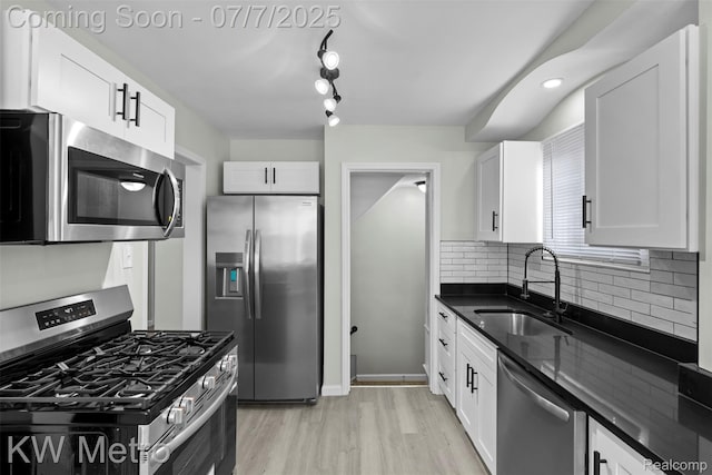 18258 Manor St, Detroit, MI 48221 - kitchen with appliances with stainless steel finishes, light wood-type flooring, white cabinetry, tasteful backsplash, and dark stone countertops