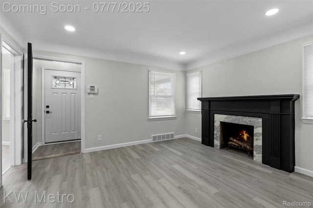 18258 Manor St, Detroit, MI 48221 - unfurnished living room featuring wood finished floors, recessed lighting, a warm lit fireplace, and ornamental molding