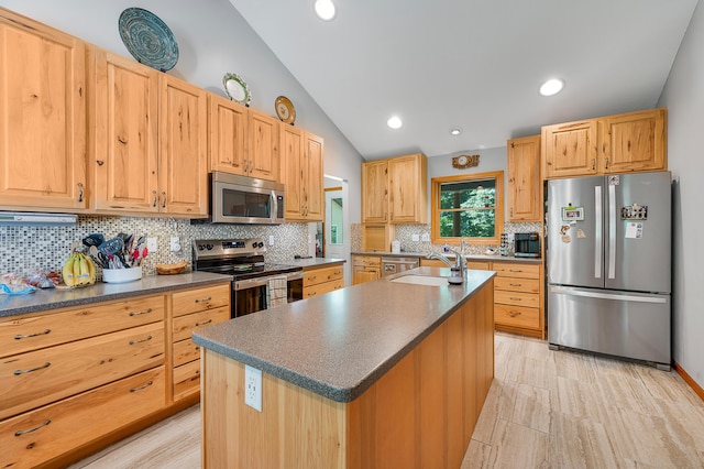 8361 9 Mile Rd, Big Rapids, MI 49307 - kitchen with stainless steel appliances, dark countertops, vaulted ceiling, tasteful backsplash, and a center island with sink