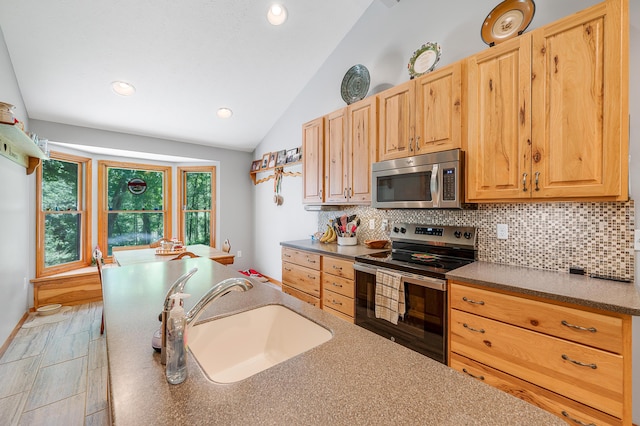 8361 9 Mile Rd, Big Rapids, MI 49307 - kitchen featuring appliances with stainless steel finishes, lofted ceiling, tasteful backsplash, dark countertops, and recessed lighting
