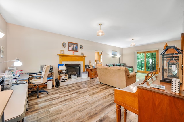 8361 9 Mile Rd, Big Rapids, MI 49307 - living room featuring wood finished floors, a tiled fireplace, and a desk