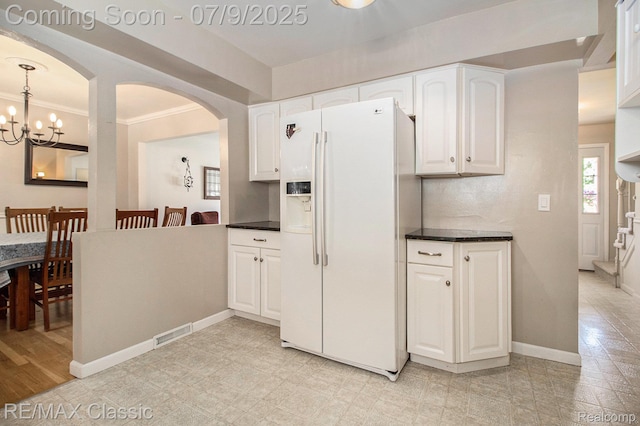 6706 Brookshire Dr, Canton, MI 48187 - kitchen with white fridge with ice dispenser, plenty of natural light, dark countertops, white cabinets, and crown molding