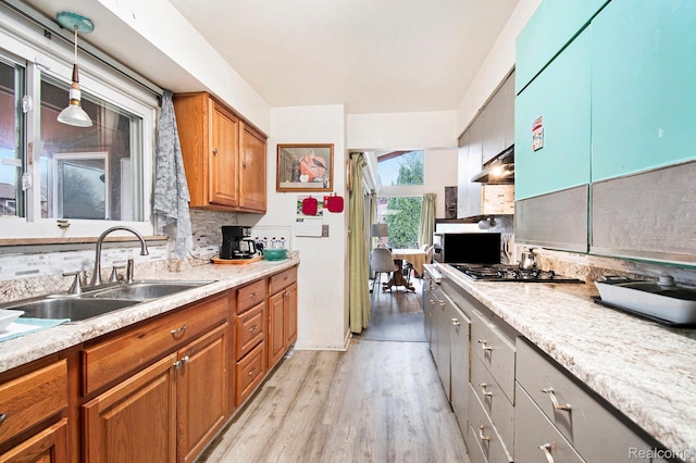 5178 Helga St, Saginaw, MI 48603 - kitchen featuring light wood-style floors, light countertops, brown cabinets, and under cabinet range hood